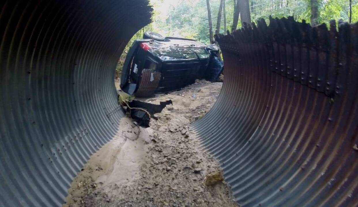 Man survives after SUV swept into raging water after road washes out