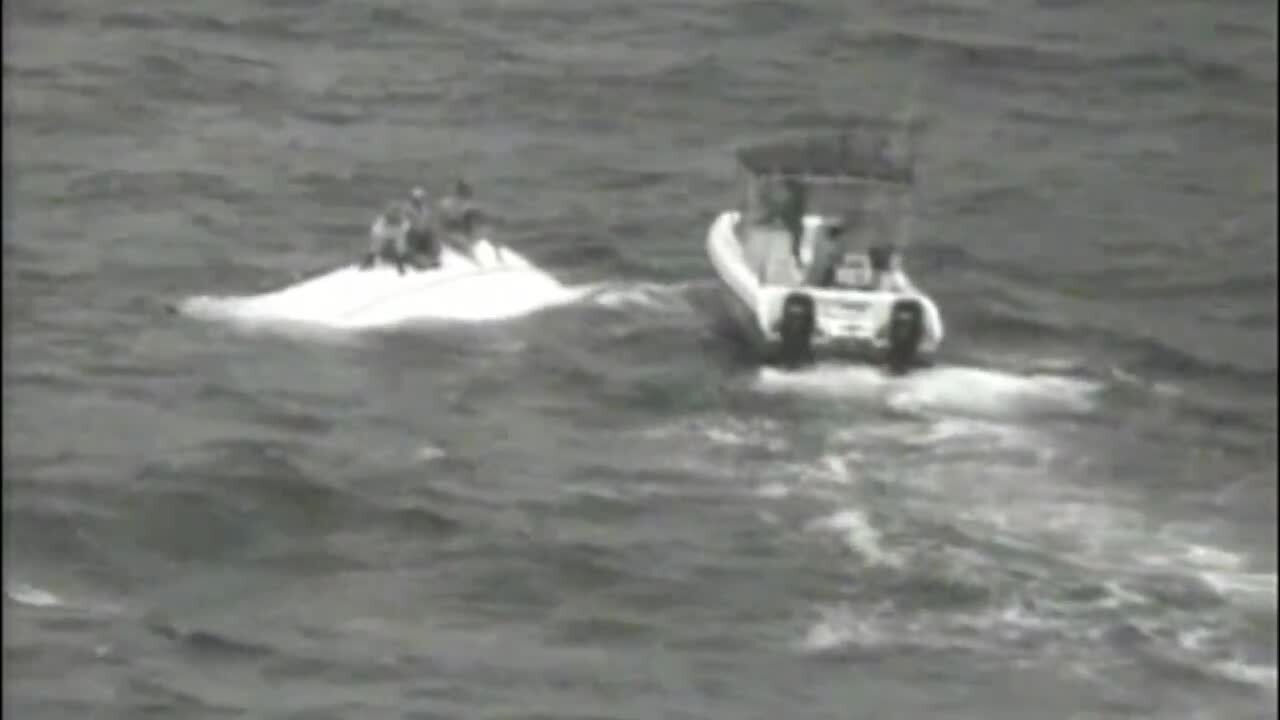 Watch as trio sitting on top of capsized boat is saved by a good Samaritan