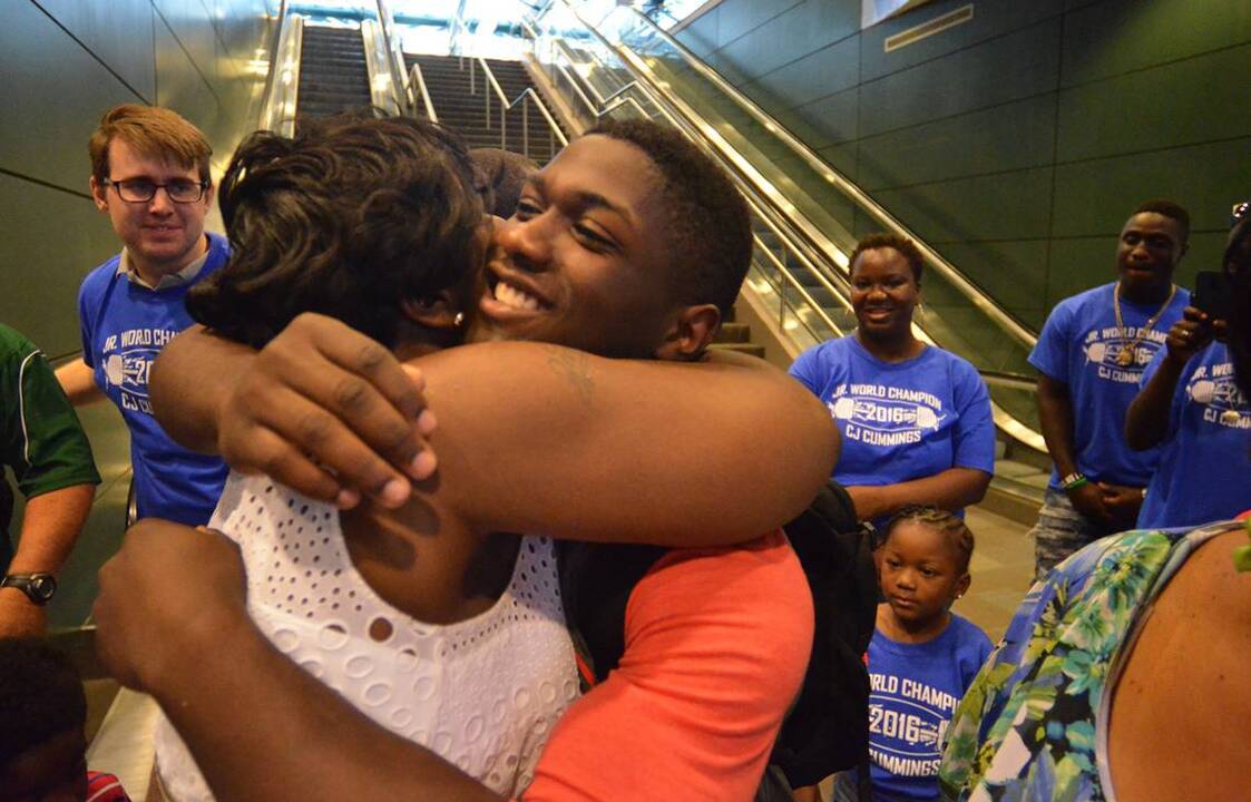Friends and family greet world record holding weightlifter CJ Cummings at the airport