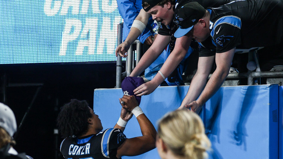 Fan gives Jalen Coker a piece of artwork at Panthers-Rams playoff game