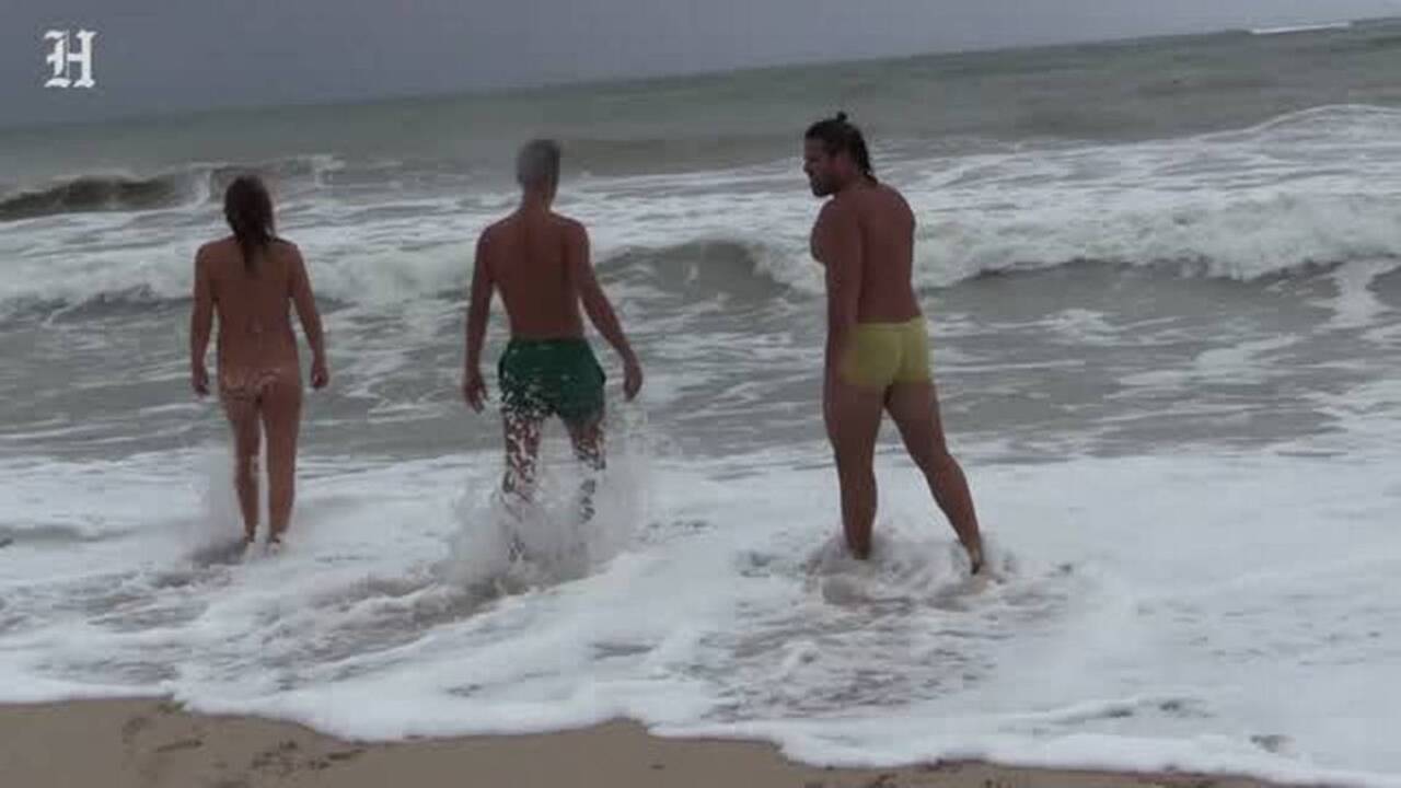 Tourists go for a swim as Hurricane Matthew passes by