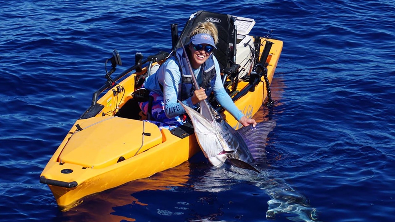 Women catches striped marlin from Kayak