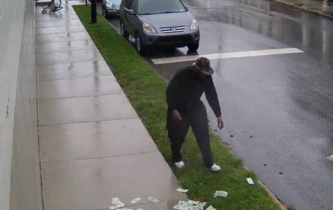 Robbery suspect fumbles wads of cash while riding away on his bicycle