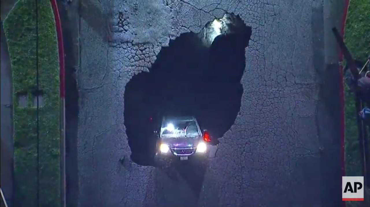 Raw: Sinkhole swallows cars amid storms