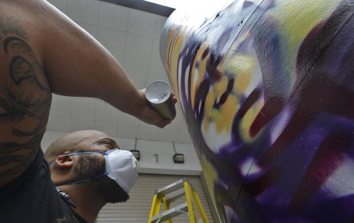 With cans of spray paint, setting the stage for a hip-hop convention in a conflicted city