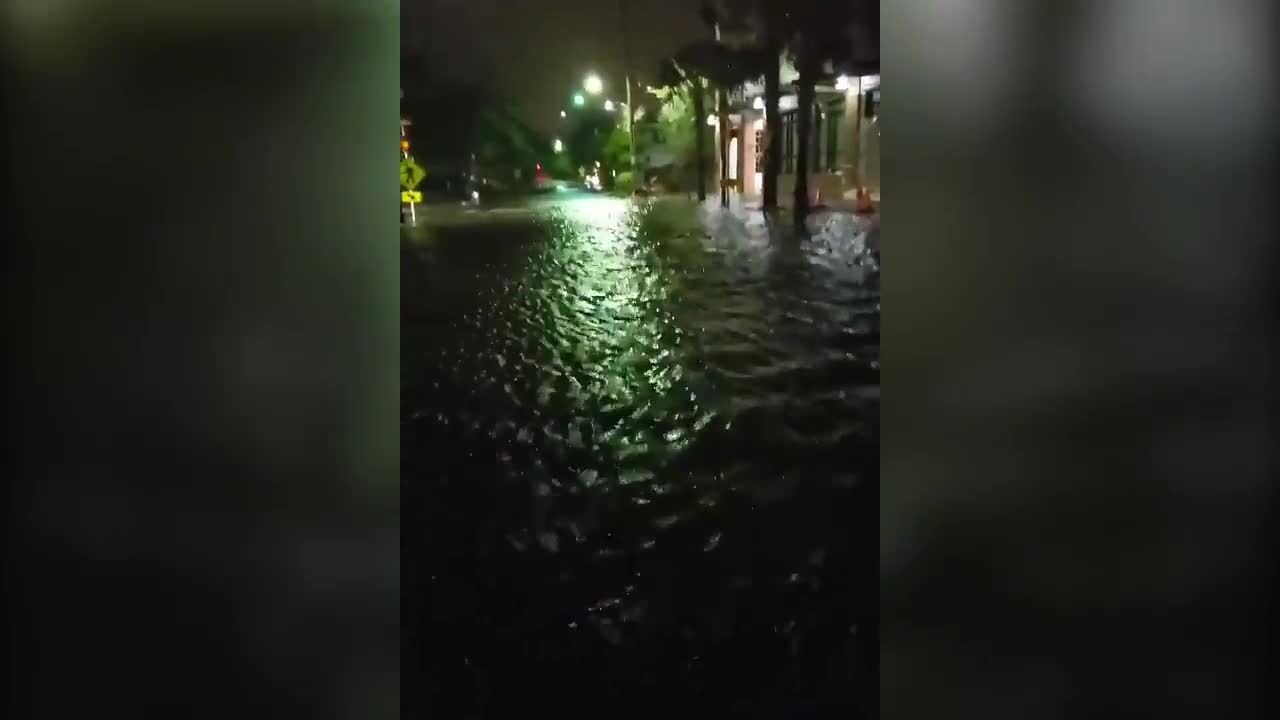 Kayakers row down flooded street in Charleston