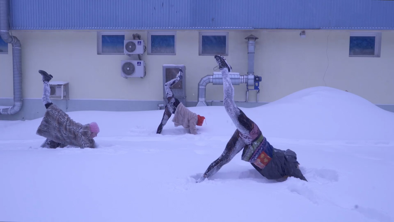 Women practice yoga in snowy Moscow