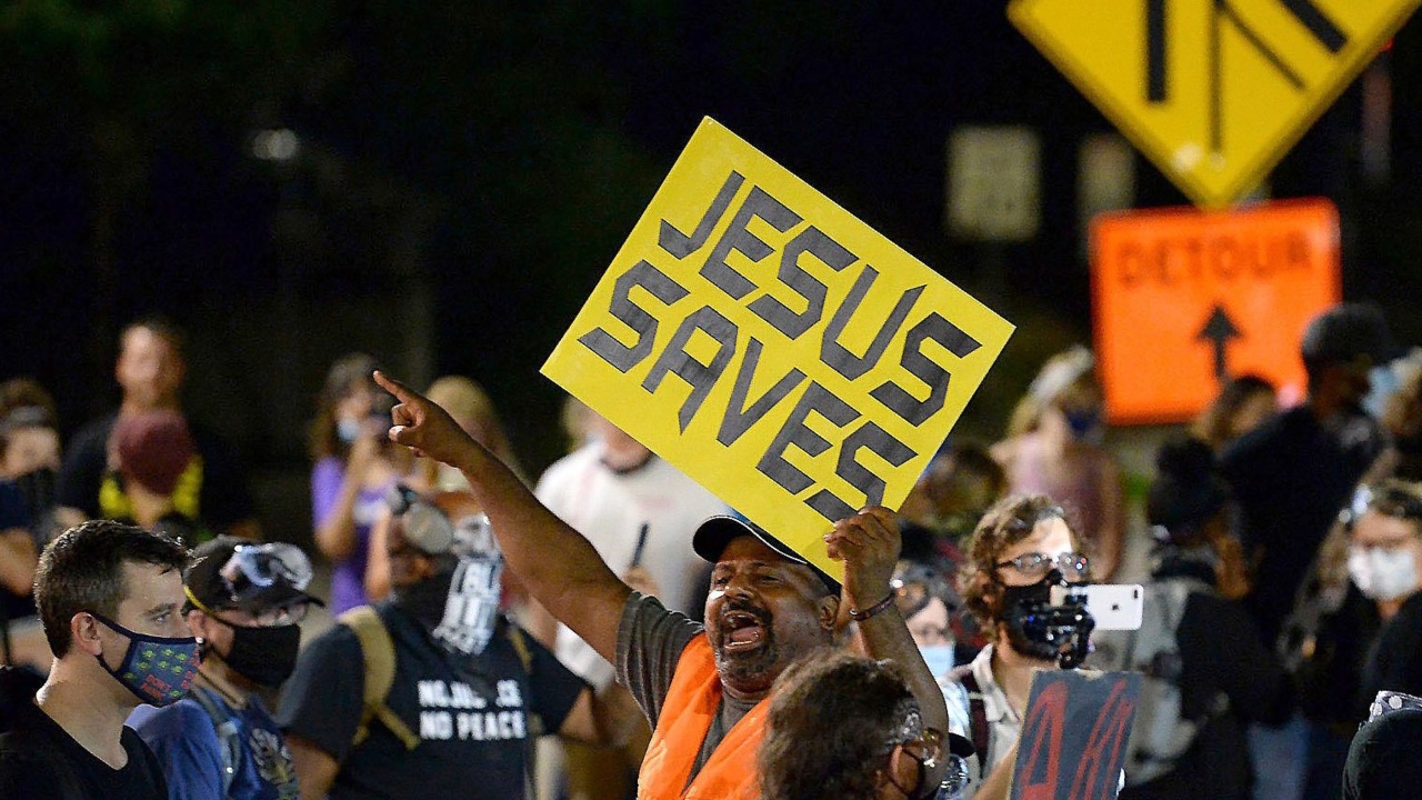 Is this man trying to share Jesus’s love with protesters? Or is he just being a nuisance?