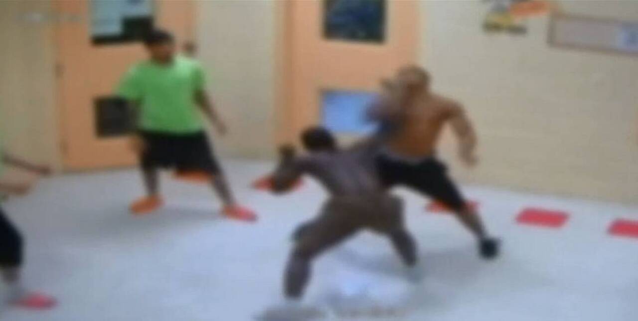Youths square off as a staffer serves as referee