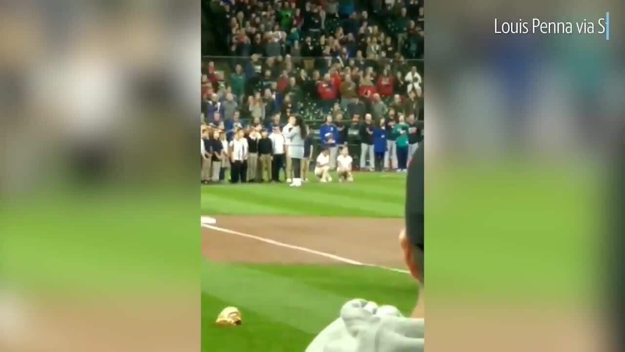 Two young girls kneel while performing national anthem at Seattle Mariners game