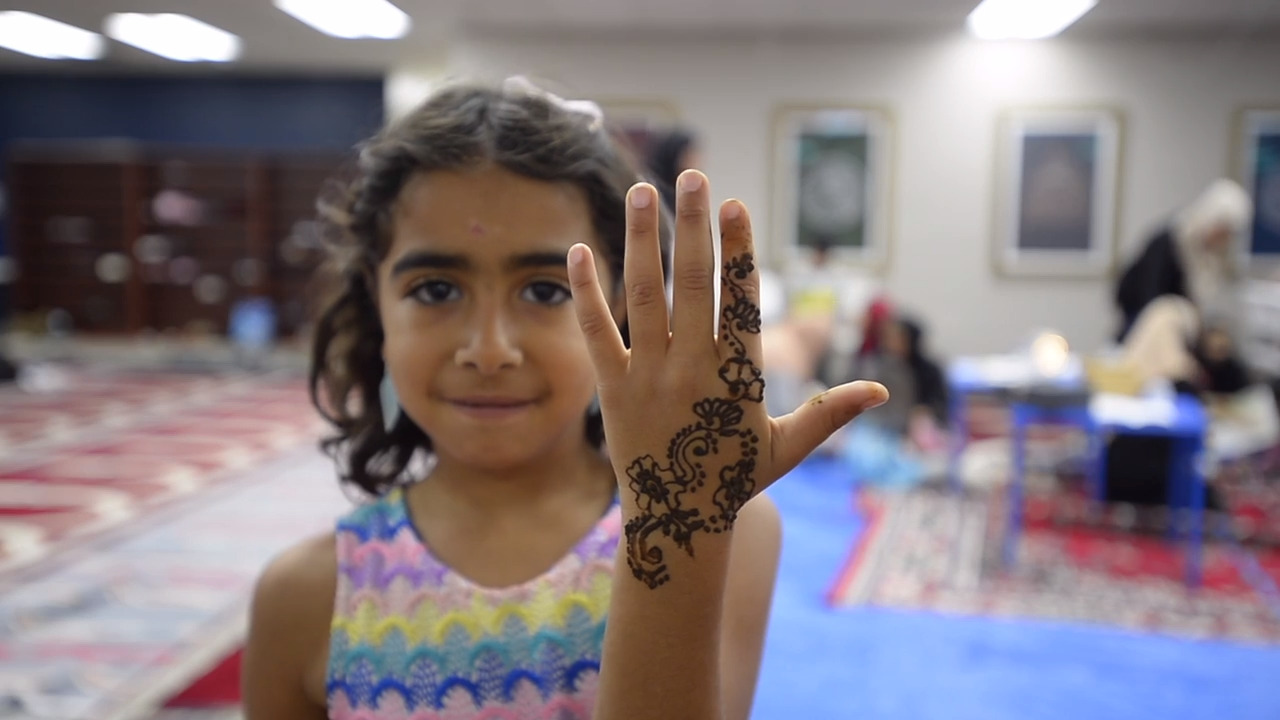 Women decorate themselves with henna in preparation for Eid