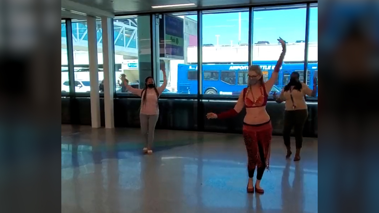 Watch a woman belly dance at a South Florida airport, and others joining too