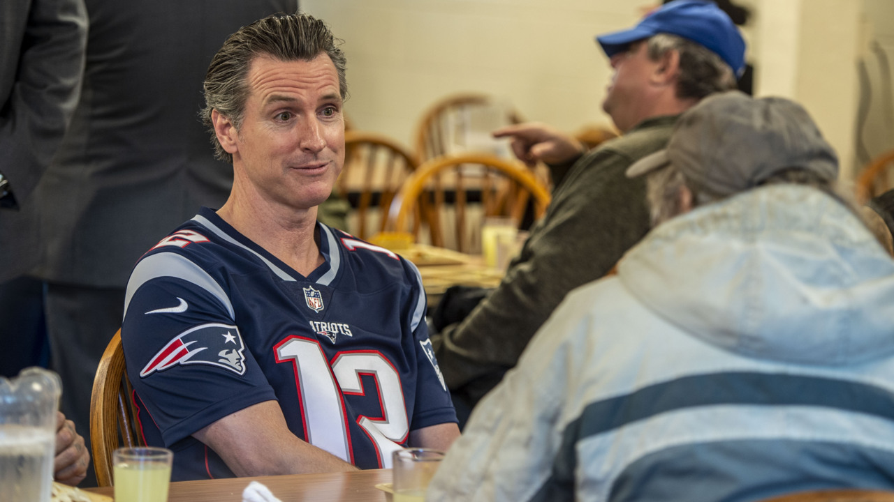 After losing bet, Gov. Newsom wears Patriots jersey to help feed homeless at Loaves & Fishes