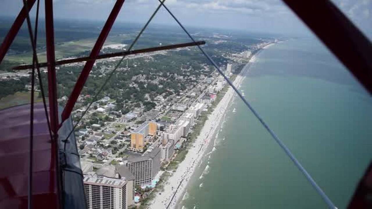 Get in the cockpit of a WWII era biplane as it flies over the Grand Strand