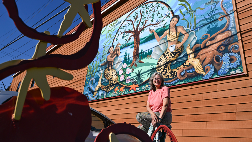Tacoma muralist Mary Mann talks public art while painting window scene