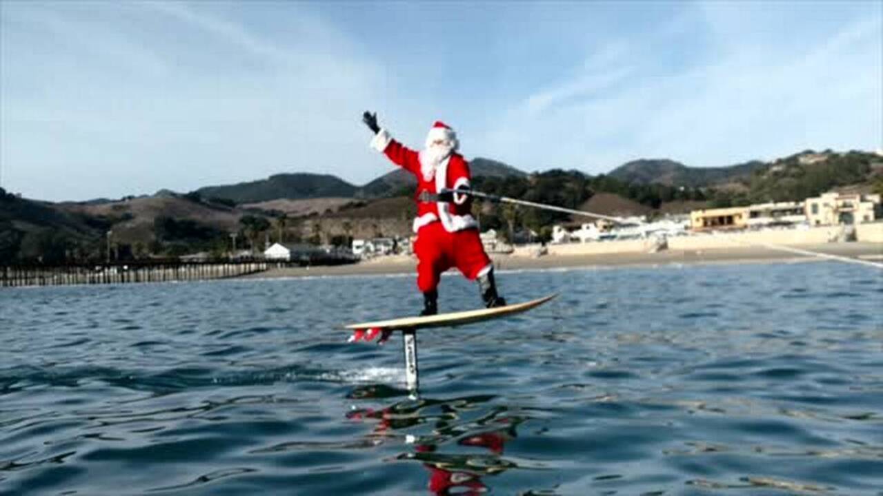 Santa Claus hits the waves on hydrofoil board in Avila Beach